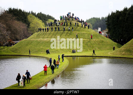 I visitatori salgono il Tumulo di lumaca nel giardino della speculazione cosmica nella motivazione della Portrack House vicino a Dumfries. Foto Stock