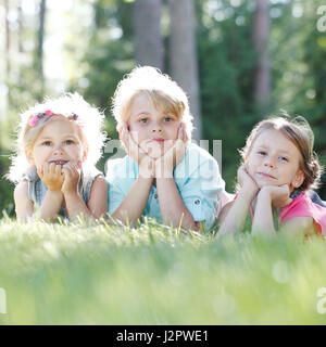 Piccoli Amici posa su erba in estate park Foto Stock