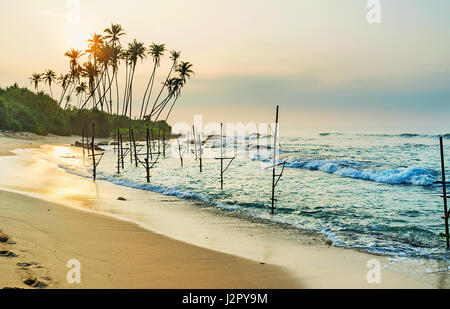 Il percorso di Rising Sun riflette nelle acque dell'oceano tempestoso sul Ahangama beach, Sri Lanka. Foto Stock