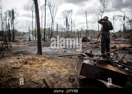 Un soldato nigeriano sta di guardia presso una raffineria illegale essendo demolita dalle forze armate nigeriane sotto il continuo funzionamento Detla cassaforte, Stato Delta, Nigeria Foto Stock