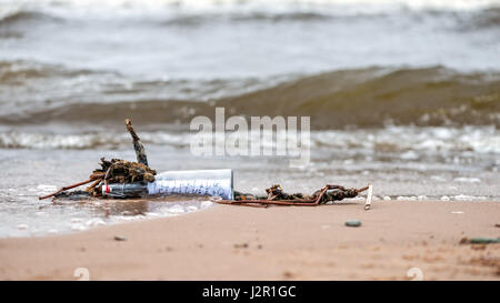 Lavata dal mare vecchia bottiglia con un messaggio. Foto Stock
