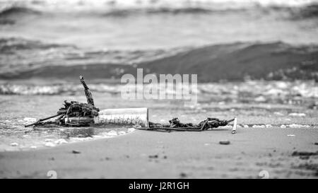 Lavata dal mare vecchia bottiglia con un messaggio. Foto Stock