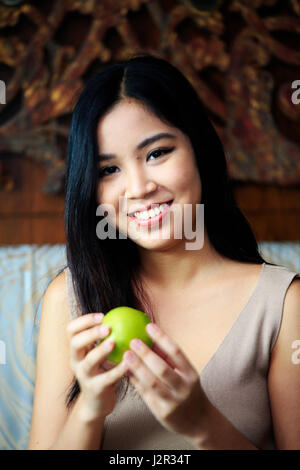 Donna asiatica tenendo un Apple Foto Stock