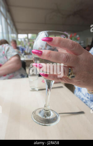 Donna che mantiene un vino vetro dipinte unghie curati a mano da bere Foto Stock