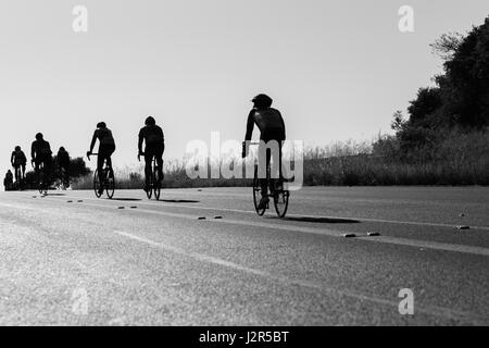 I ciclisti Escursioni in bicicletta su per la collina profilarsi la gara su strada Foto Stock