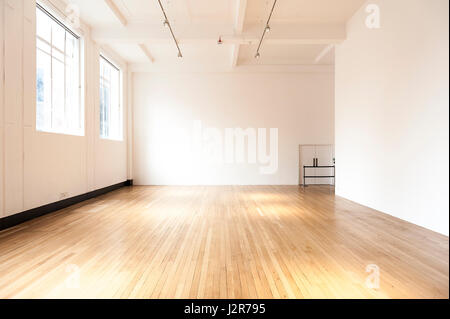 Stanza vuota con le pareti bianche e pavimento in parquet Foto Stock