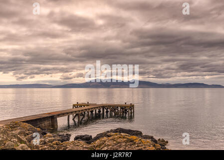 Il castello antico molo al Portencross in Seamill Ayrshire in Scozia con Arran colline nel retro di massa. I cieli sono pesanti poco prima ha piovuto come Foto Stock