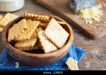 In casa croccante sottile cheesy crackers con semi di sesamo in legno rustico bowl - organico fresco in casa la cottura cheese crackers snack Foto Stock