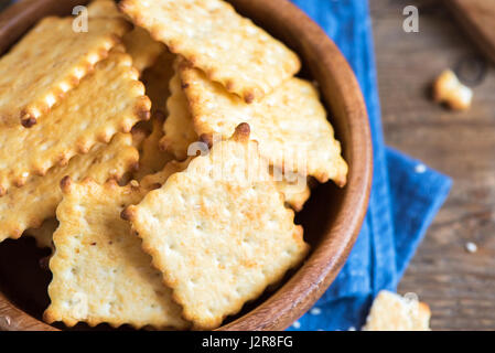 In casa croccante sottile cheesy crackers con semi di sesamo in legno rustico bowl - organico fresco in casa la cottura cheese crackers snack Foto Stock