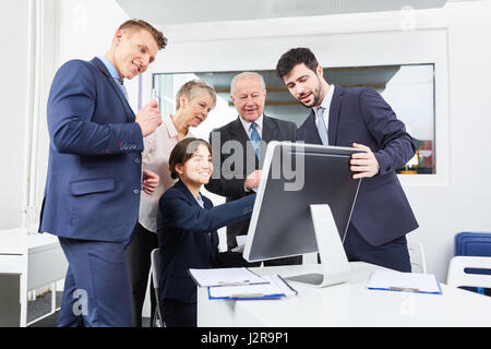 Il team Aziende nella parte anteriore del computer per chiamata in videoconferenza Foto Stock