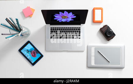 Moderno artista digitale dell'area di lavoro comprendente computer laptop, pen tablet, ipad fotocamera e disco rigido Foto Stock