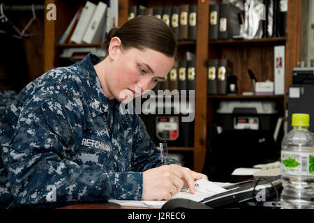 170425-N-JD834-001 NAVAL AIR FACILITY Atsugi, Giappone (25 aprile 2017) la manutenzione aeronautica Administrationman 1a classe Amy Kretchman, da Pekin, Ill., completa di documenti cartacei come parte dei suoi doveri come log e record principali petty officer per l'elicottero mare squadrone di combattimento (HSC) 12 Golden falchi. Kretchman era stato annunciato come uno dei cinque destinatari del 2017 Navy visionario Leadership Awards. (U.S. Foto di Marina di Massa lo specialista di comunicazione 2a classe Michael Doan/RILASCIATO) Foto Stock