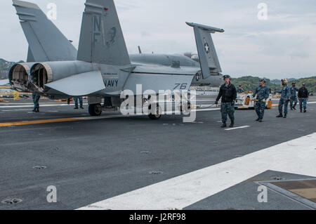 170426-N-PF593-005 Yokosuka, Giappone (26 aprile 2017) i marinai a bordo della marina in avanti solo schierate portaerei USS Ronald Reagan CVN (76), spostare un aeromobile da marcia avanti a poppa sul ponte di volo. La aviation boatswain compagni spostato il velivolo come corsi di formazione per le operazioni di volo. Ronald Reagan, il portabandiera del Carrier Strike gruppo 5, fornisce un combattimento-pronto forza che protegge e difende la collettiva degli interessi marittimi dei suoi alleati e partner in Indo-Asia-regione del Pacifico. (U.S. Foto di Marina di Massa Communications Specialist 2a classe Jamal McNeill/rilasciato) Foto Stock