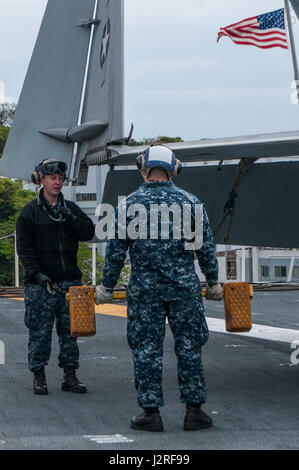 170426-N-PF593-031 Yokosuka, Giappone (26 aprile 2017) dell'aviazione di Boatswain Mate Airman Andrew Whiting, da Conway, Carolina del Sud e Airman reclutare Jose Huertasfeliciano, da Deltona, Florida preparare per fissare un aeromobile per il ponte di volo della Marina è solo distribuita portaerei USS Ronald Reagan (CVN 76). Merlano e Huertasfeliciano ha contribuito a guidare il velivolo durante il suo movimento dalla posizione di avanzamento a poppa sul ponte di volo. Ronald Reagan, il portabandiera del Carrier Strike gruppo 5, fornisce un combattimento-pronto forza che protegge e difende la collettiva degli interessi marittimi dei suoi alleati una Foto Stock