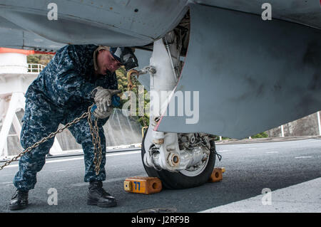 170426-N-PF593-062 Yokosuka, Giappone (26 aprile 2017) Airman reclutare Jose Huertasfeliciano, da Deltona, Florida fissa un aeromobile per il ponte di volo della Marina è solo distribuita portaerei USS Ronald Reagan (CVN 76). Huertasfelician assistiti in movimento di un aeromobile in volo deck. Ronald Reagan, il portabandiera del Carrier Strike gruppo 5, fornisce un combattimento-pronto forza che protegge e difende la collettiva degli interessi marittimi dei suoi alleati e partner in Indo-Asia-regione del Pacifico. (U.S. Foto di Marina di Massa Communications Specialist 2a classe Jamal McNeill/Release Foto Stock