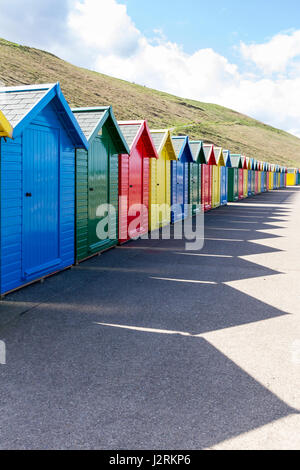 Riga delle colorate cabine in legno lungo la West Cliff promenade a Whitby, North Yorkshire, Inghilterra, Regno Unito Foto Stock