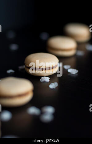 Amaretti con crema di cioccolato ordinati in linea decorato con ciottoli e sabbia Foto Stock