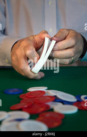 L'uomo rimescolare le carte di fronte al gioco di Poker Foto Stock