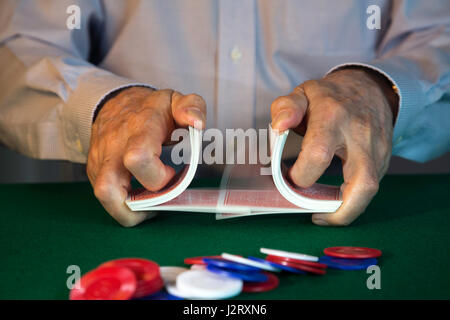 L'uomo rimescolare le carte di fronte al gioco di Poker Foto Stock