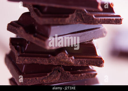 Cioccolato fondente pezzi su sfondo grigio scuro Foto Stock