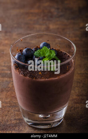 Budino di cioccolato con frutti di bosco ed erbe aromatiche, vintage rustico stile alimentare foto, per la tua pubblicità Foto Stock