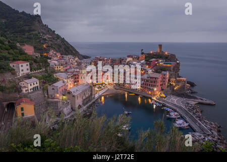 Il borgo di vernazza nelle cinque terre in Liguria, Italia insieme contro un nuvoloso cielo grigio al tramonto Foto Stock