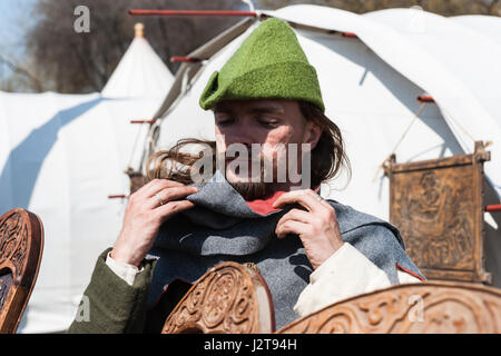 Mosca, Russia. 30 apr, 2017. Festa medievale e internazionale di Saint George lancia in esecuzione ha luogo in corrispondenza di Kolomenskoe park. Il torneo è completamente evento commerciale nascosta dietro le mura e recinti del tilt-cantiere, festa medievale è per il pubblico in generale. Un sacco di divertimento per adulti e bambini. L uomo non identificato nel verde cappello medievale sorge dalla tenda e regola la sua felpa con cappuccio. Robin regola un cofano. Sembra che sarebbe un interessante notte a Nottingham. Credito: Alex immagini - Mosca/Alamy Live News Foto Stock