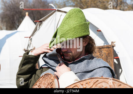 Mosca, Russia. 30 apr, 2017. Festa medievale e internazionale di Saint George lancia in esecuzione ha luogo in corrispondenza di Kolomenskoe park. Il torneo è completamente evento commerciale nascosta dietro le mura e recinti del tilt-cantiere, festa medievale è per il pubblico in generale. Un sacco di divertimento per adulti e bambini. L uomo non identificato nel verde cappello medievale sorge dalla tenda e regola la sua felpa con cappuccio. Robin regola un cofano. Sembra che sarebbe un interessante notte a Nottingham. Credito: Alex immagini - Mosca/Alamy Live News Foto Stock