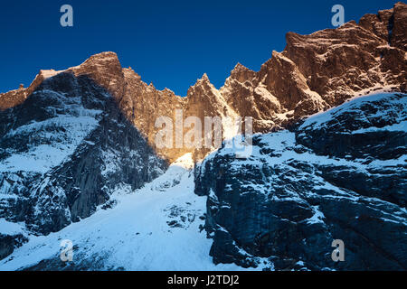 La prima mattina la luce sul 3000 piedi verticale Parete Troll (appena a sinistra del centro), e i picchi Trolltindane, in valle Romsdalen, Møre og Romsdal, Norvegia. Foto Stock