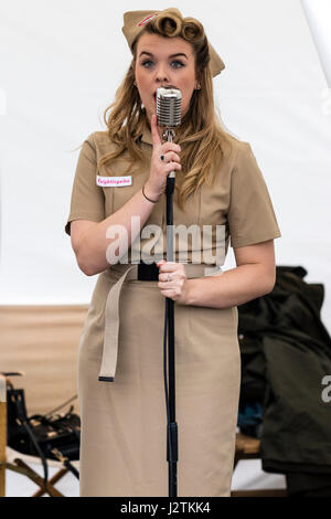 Saluto alla 40s rievocazione giorno. Il cantante da Knightingales, un trio di donne un gruppo di canto in WAAF uniformi, sul palco di eseguire la guerra mondiale due canzoni Foto Stock