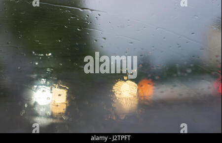 La pioggia - vista offuscata dall'interno dell'auto, dietro il parabrezza Foto Stock