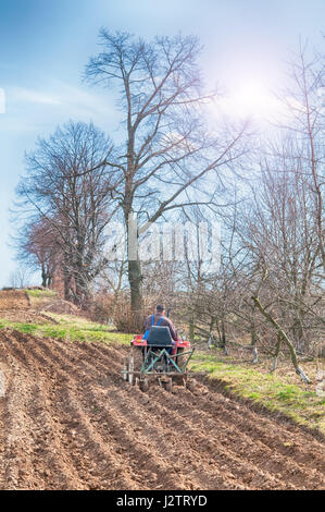 Il trattore su un campo primaverile. Close up Foto Stock