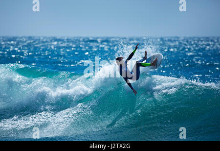 Un surfista cavalca un'onda nell'Oceano Atlantico in Portogallo Foto Stock