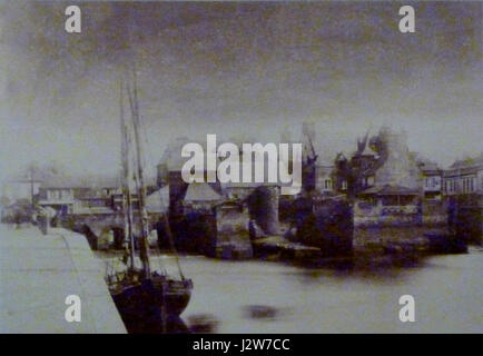 Una fotografia anonima del 1860 circa raffigurante il ponte coperto ("pont couvert") e il porto di Landerneau, un comune della Bretagna, in Francia. L'immagine cattura le caratteristiche architettoniche del ponte e la vivace attività portuale dell'epoca, fornendo uno sguardo storico sulle infrastrutture della regione e sulla vita quotidiana. Foto Stock