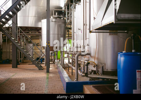 Fabbricazione di birra linea. Attrezzature per la messa in scena di imbottigliamento di produzione di prodotti alimentari finiti. Strutture metalliche, tubazioni e serbatoi in fabbrica enterprise. Sp Foto Stock