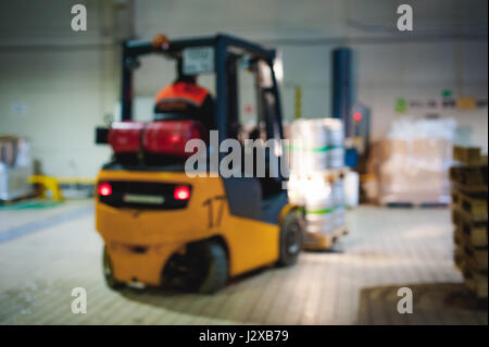 Dipendente del magazzino in tute vestiti, driver Reachtruck occupato a lavorare sulla logistica spostando sul caricatore su pallet con barili di birra sulla linea di fabbrica per pro Foto Stock