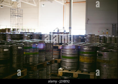 La birra in fusti. Molti metallico barile di birra stand in righe in un magazzino Foto Stock