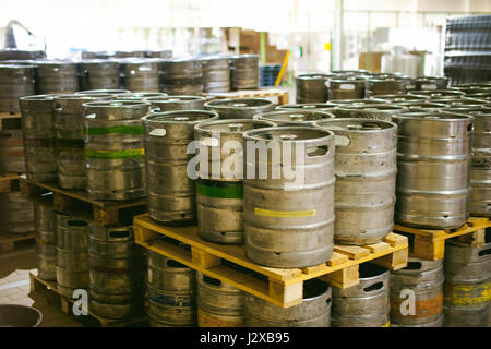 La birra in fusti. Molti metallico barile di birra stand in righe in un magazzino Foto Stock