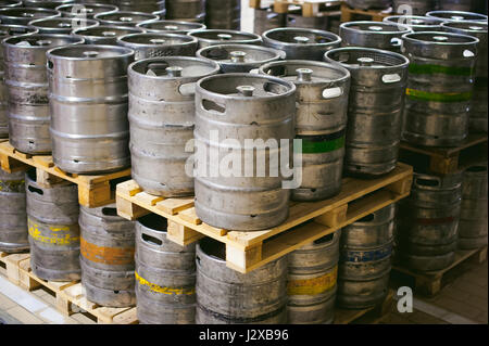 La birra in fusti. Molti metallico barile di birra stand in righe in un magazzino Foto Stock