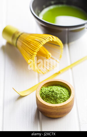 Verde matcha tè in polvere nella ciotola e mescolare con una frusta di bambù. Foto Stock