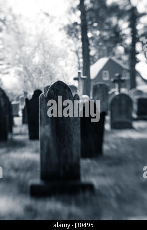 Vecchie lapidi sfocate sono visti in un cimitero. Foto Stock