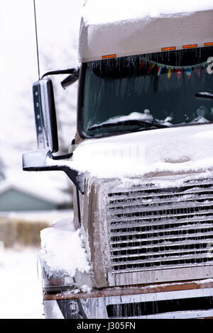 Grande marrone moderno semi carrello cromato con griglia e le luci di testa nella neve e nel ghiaccio Foto Stock