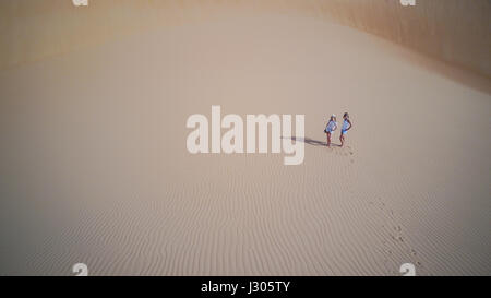 Due donne in piedi su una duna di sabbia come visto da un drone. Liwa desert, UAE. Foto Stock