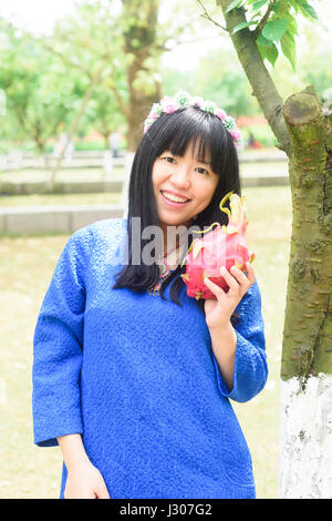 Bella ragazza tenendo pitaya nella natura Foto Stock