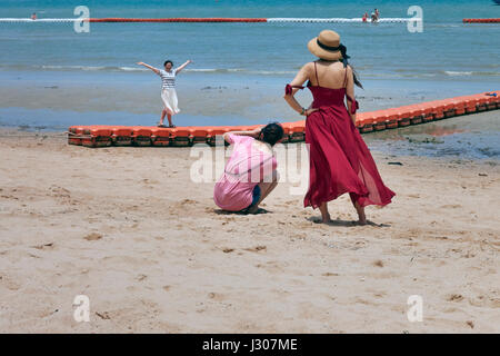 Donna di prendere una fotografia del suo amico in spiaggia. Foto Stock