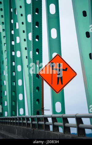 Luminoso spia arancione cartello stradale informare i driver che vengono forniti con il flagger stop presso il sito di riparazione della strada. Il segno è montato su un me Foto Stock