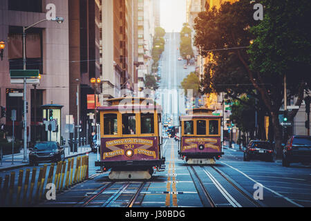 Visualizzazione classica della storica tradizionale cavo auto equitazione sulla famosa California Street nel bellissimo inizio. La luce del mattino al sorgere del sole in estate con retro vi Foto Stock