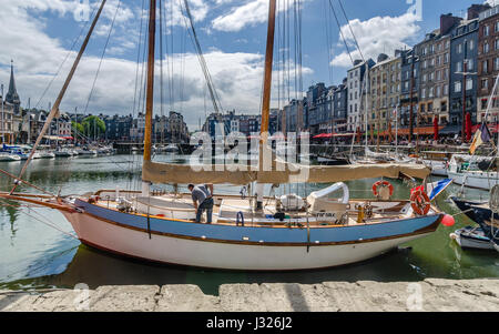 L'uomo la pulizia di una barca in Honfleur Foto Stock