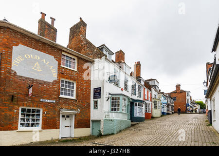 In acciottolato Quay collina con pittoreschi locali caratteristici edifici storici che portano a Quay Street e il porto a Lymington, Hampshire, costa sud dell'Inghilterra Foto Stock