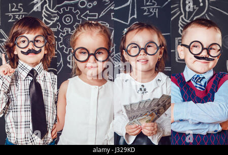 Collage di ritratti di bambini in stile business. I bambini in bicchieri su uno sfondo nero con grafici. Foto Stock